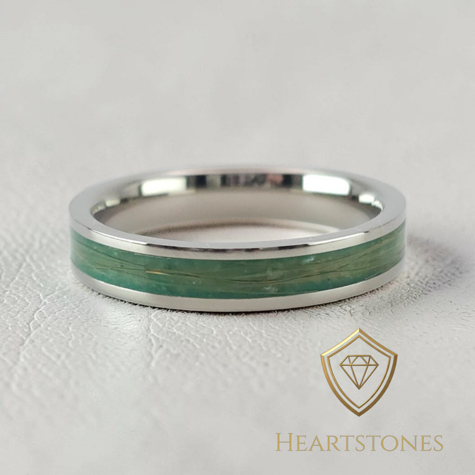 “Sterling silver memorial band ring with preserved hair in green inlay, flush set and meticulously finished by hand by Heartstones®”